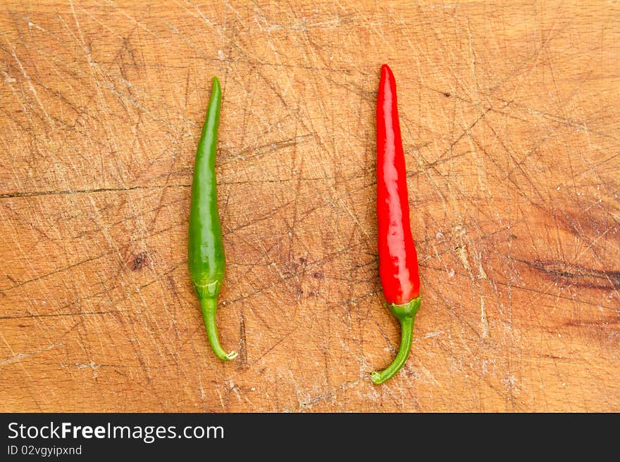 Two chilli peppers on a cutting board. Two chilli peppers on a cutting board