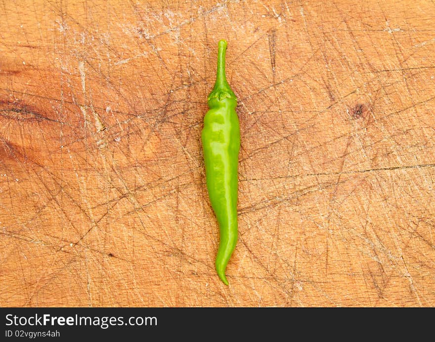 Green chilli pepper on a cutting board