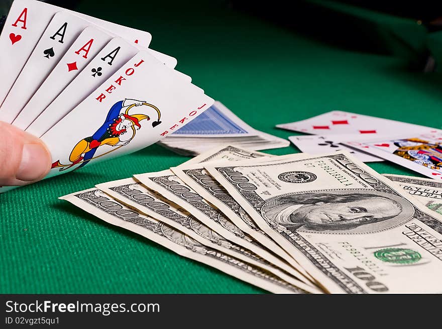 Poker cards showing poker and dollars on green cloth