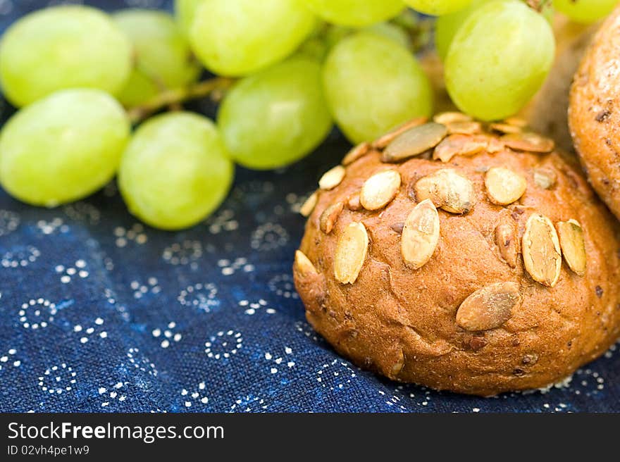 Bread with grapes on blue canvas