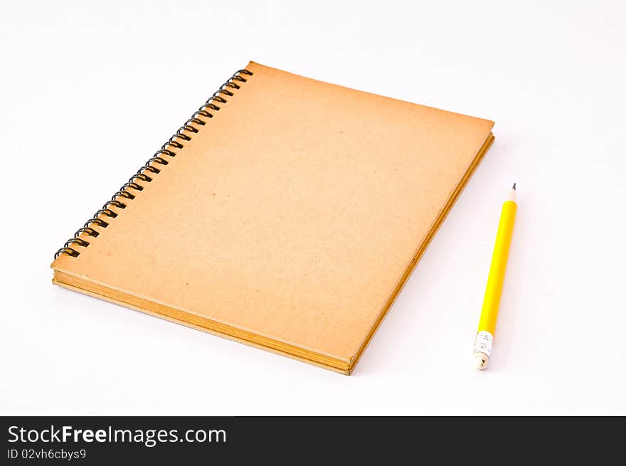 Brown Spiral Notebook with yellow pencil