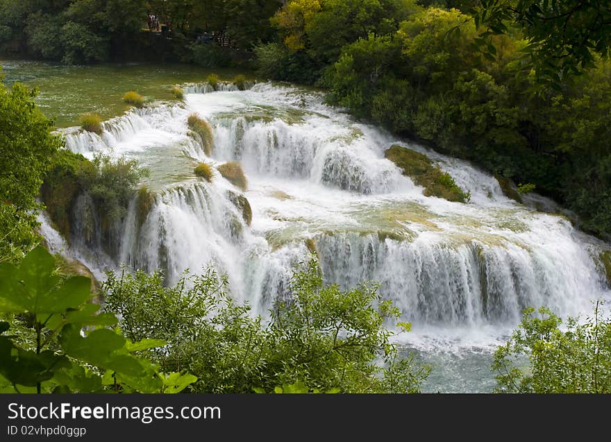 View of the waterfall surrounded by trees from the top of