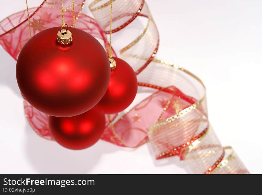 Hanging red glass balls with the ribbon on the white background. Hanging red glass balls with the ribbon on the white background