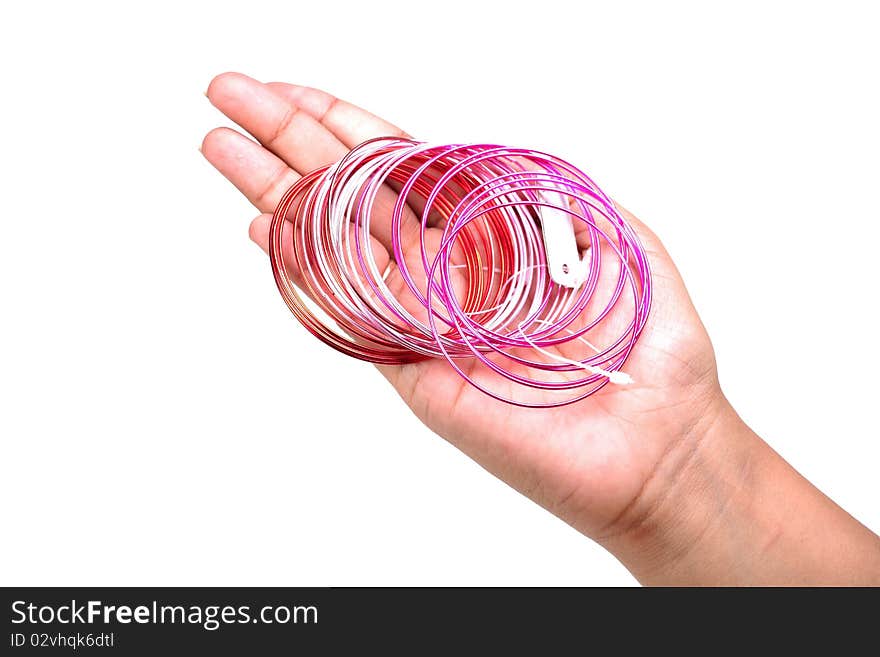 Female hand holding metal bangles on white background.