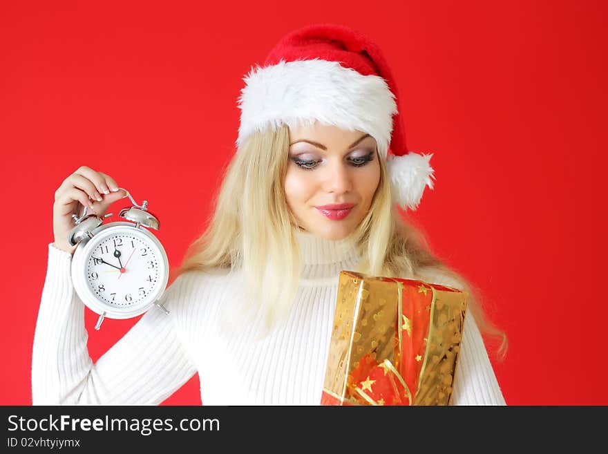 Attractive girl holding an alarm clock with box