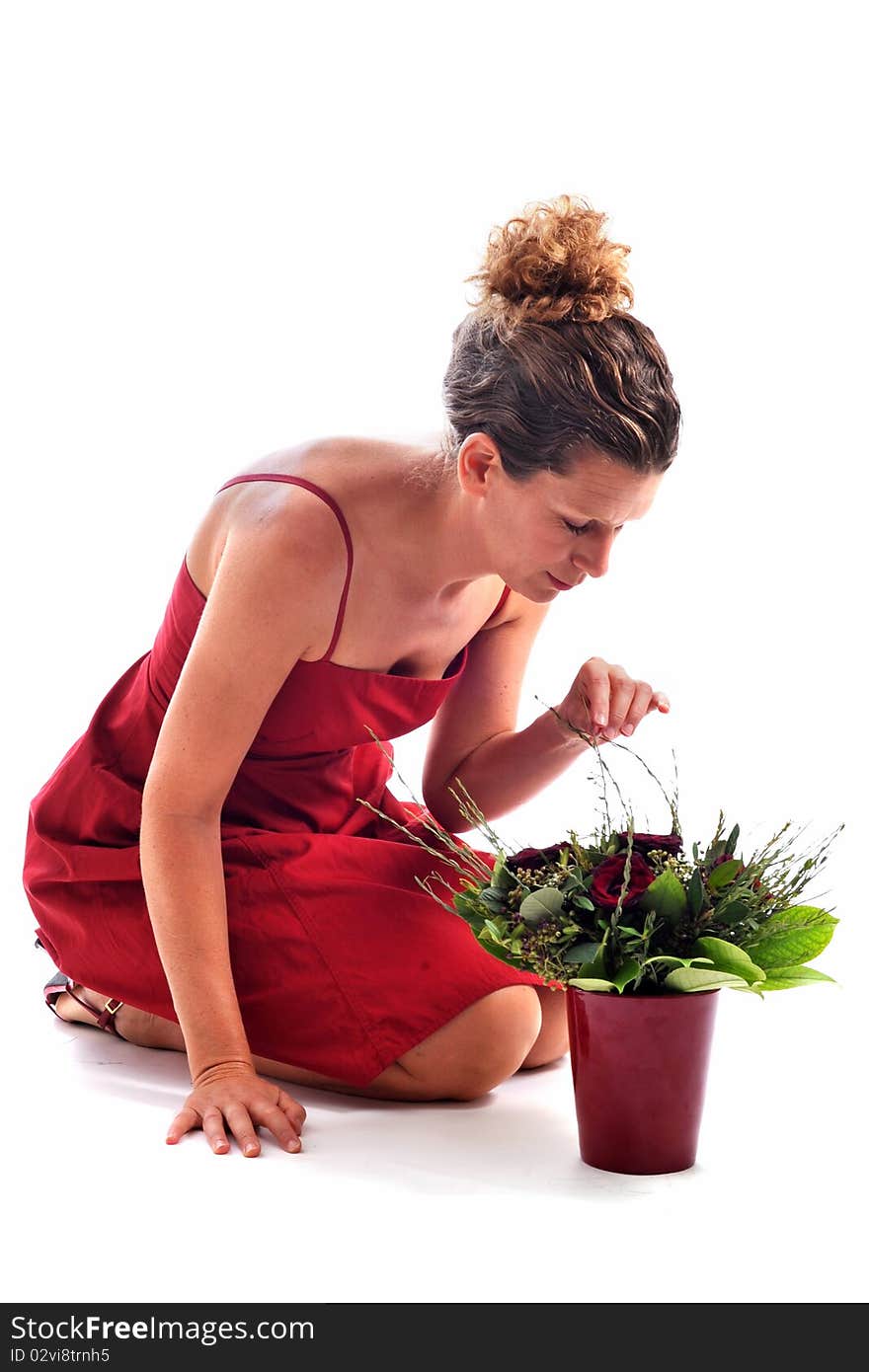 Beautiful woman arranging flowers in front of a white background. Beautiful woman arranging flowers in front of a white background