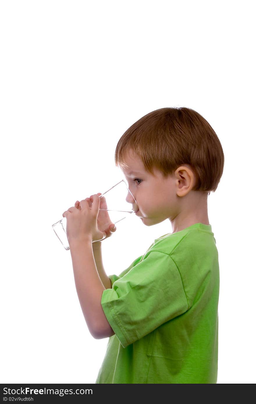 Boy drinks water from a glass on a white background