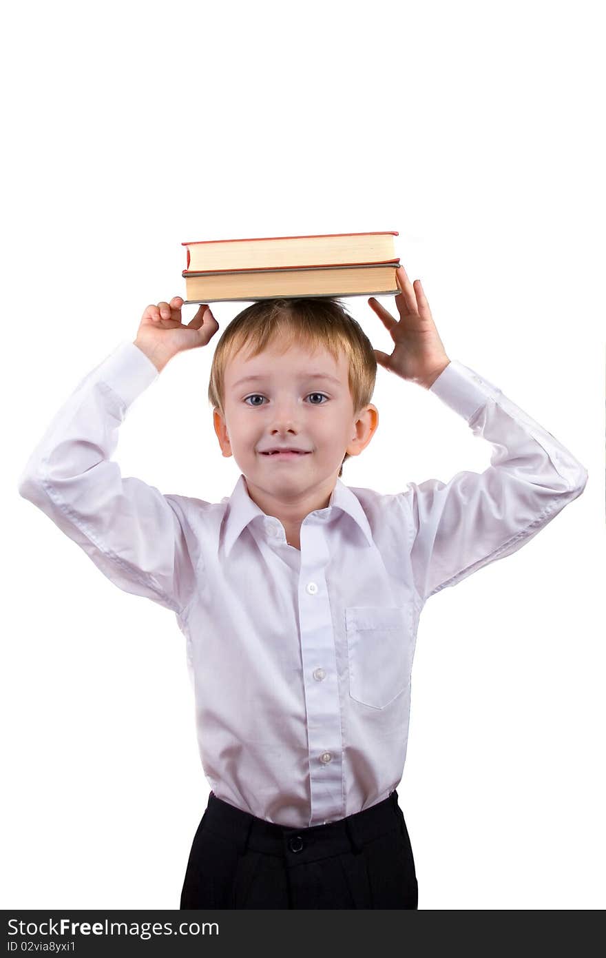 Happy boy with a stack of books on his head on a white background