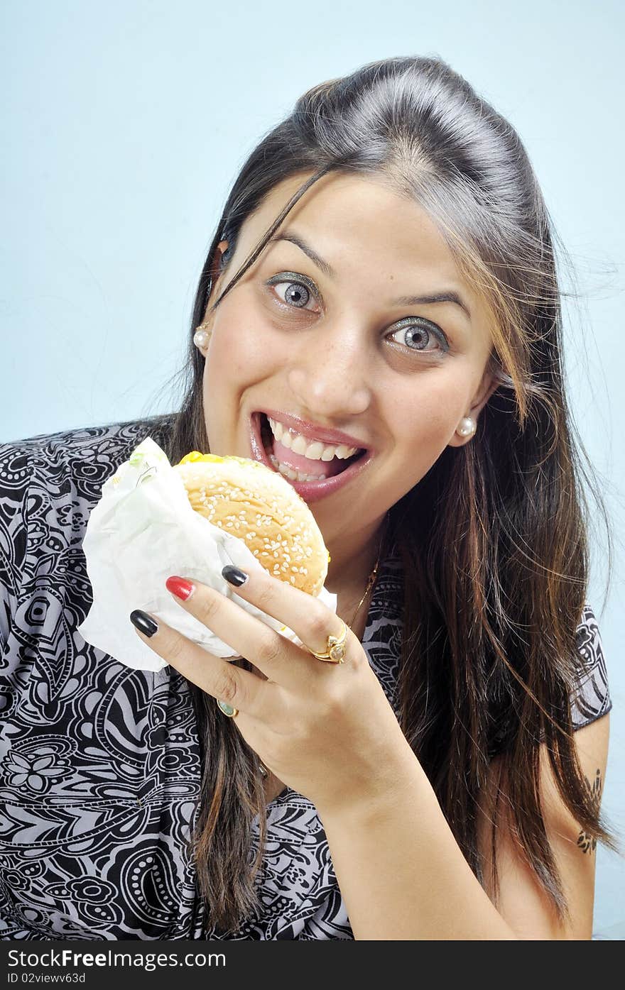 Model making faces while holding veg burger. Model making faces while holding veg burger.