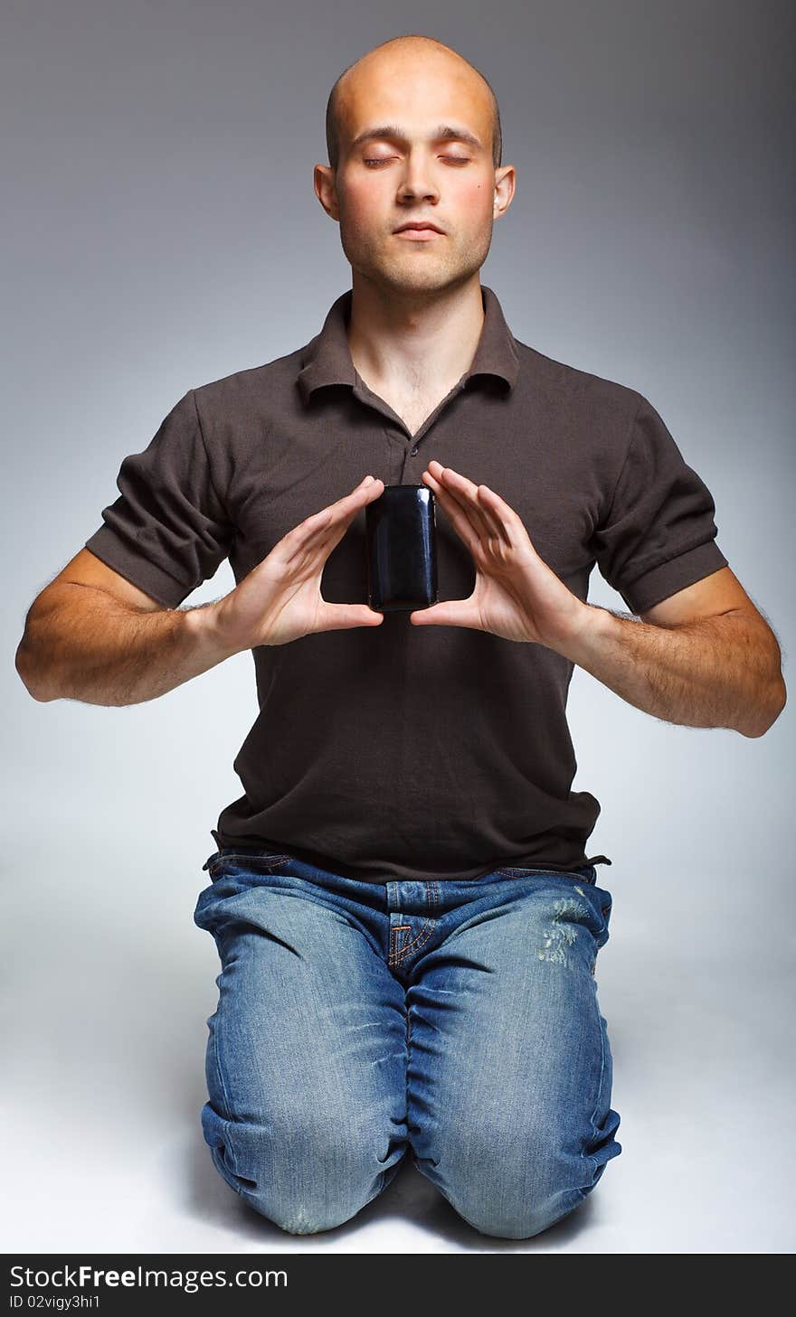 Young handsome man sitting with phone