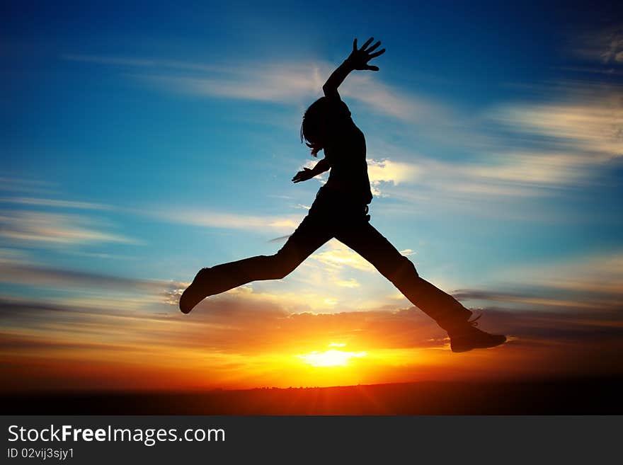 Young woman jumping with raised hands