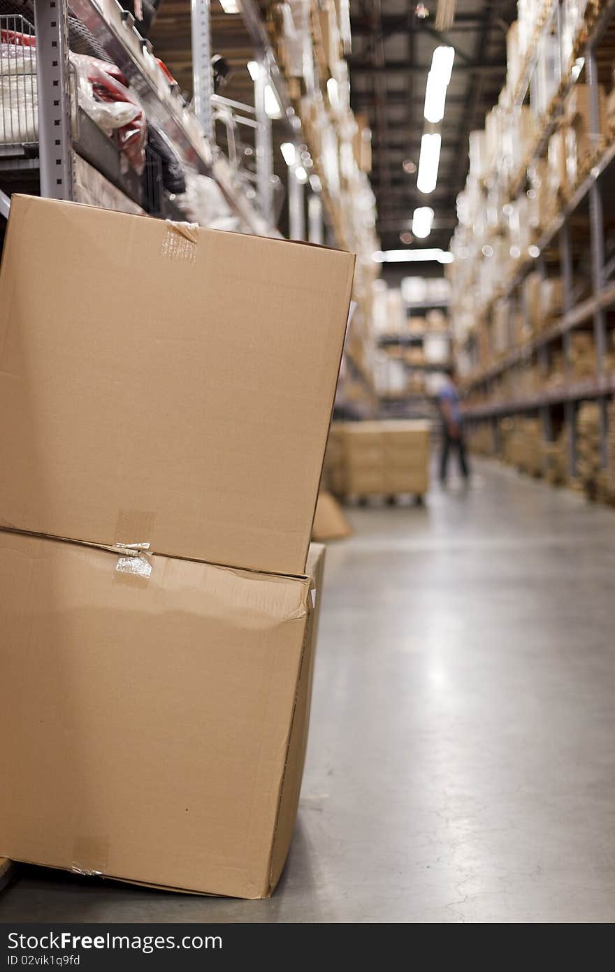 A view of the warehouse aisle with cardboard packages in the foreground. Shallow DOF. A view of the warehouse aisle with cardboard packages in the foreground. Shallow DOF