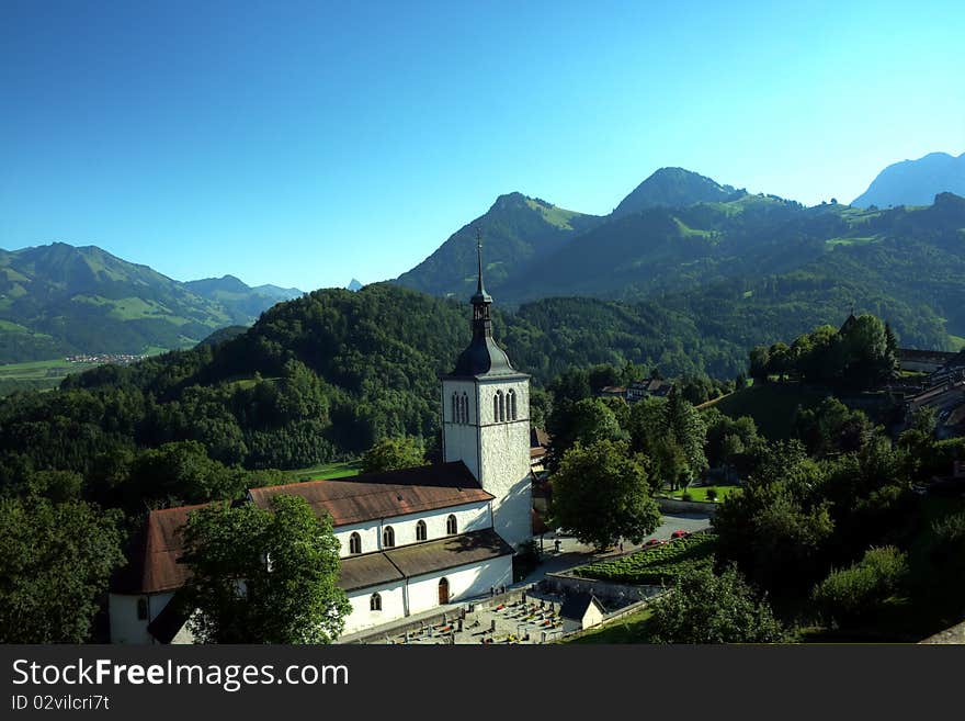 Image taken from Château de Gruyères (Gruyères Castle) with the beautiful Alps in the background on a summer day. Image taken from Château de Gruyères (Gruyères Castle) with the beautiful Alps in the background on a summer day.