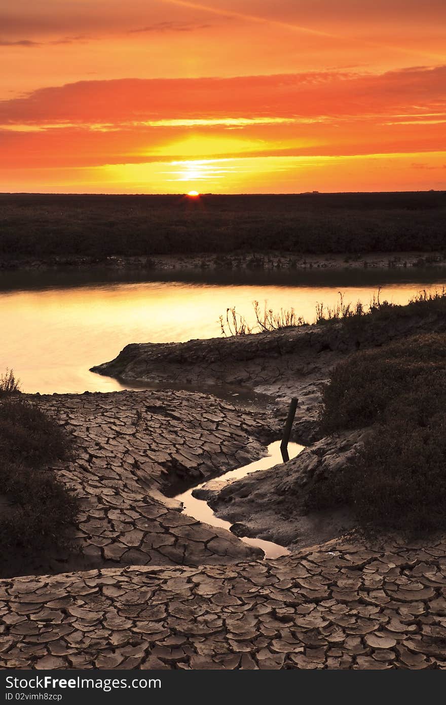 Cracked mud on the shore of Thornham harbor at sunrise. Cracked mud on the shore of Thornham harbor at sunrise