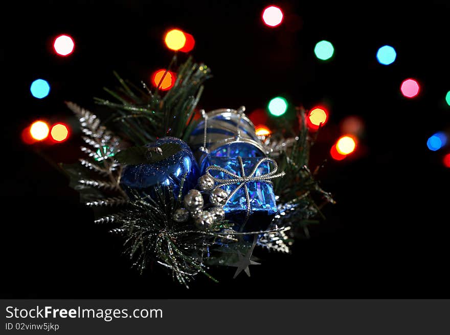 A holiday decoration in front of holiday colored lights. A holiday decoration in front of holiday colored lights