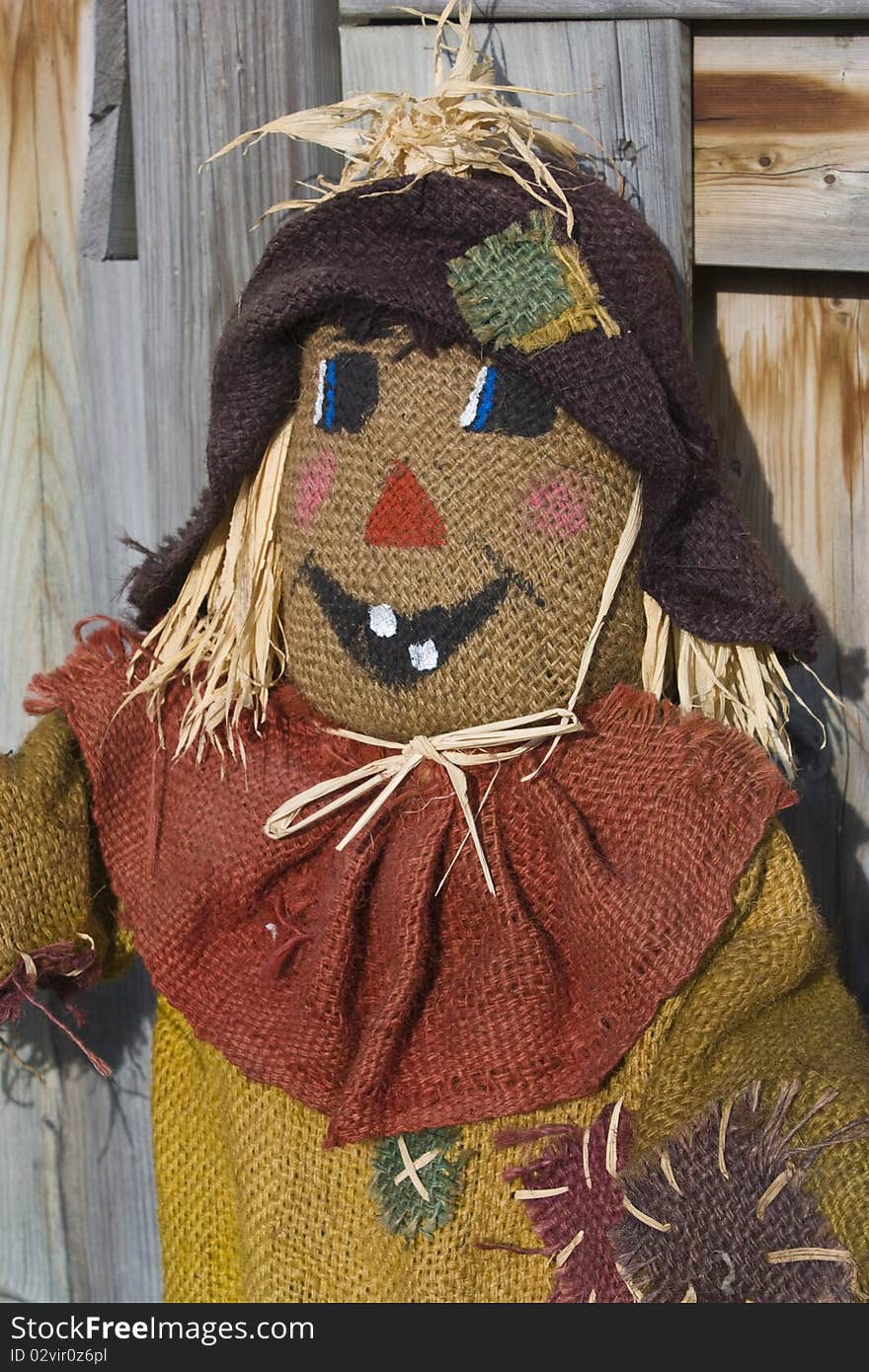 Closeup of scarecrow with a wooden fence in the background used as fall decoration. Closeup of scarecrow with a wooden fence in the background used as fall decoration