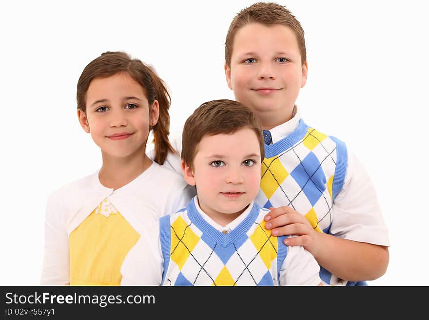 Two brothers and sister in matching outfits over white background. Two brothers and sister in matching outfits over white background.