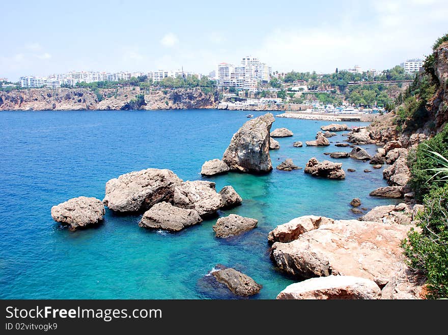 Cliffs and the sea in turkey. Sea surface with rocks.Blue clear water of sea. Cliffs and the sea in turkey. Sea surface with rocks.Blue clear water of sea