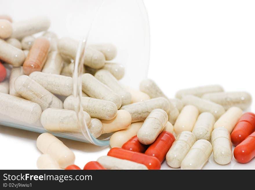 Pills in a glass isolated on white background