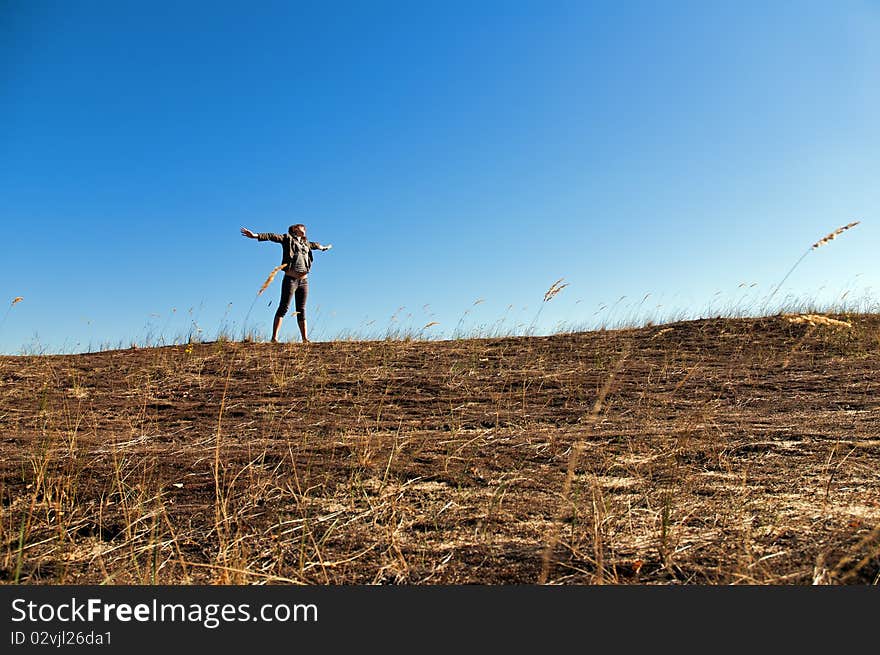 A beautiful young woman experiencing freedom or good time among dunes in the recent warm days of autumn. A beautiful young woman experiencing freedom or good time among dunes in the recent warm days of autumn