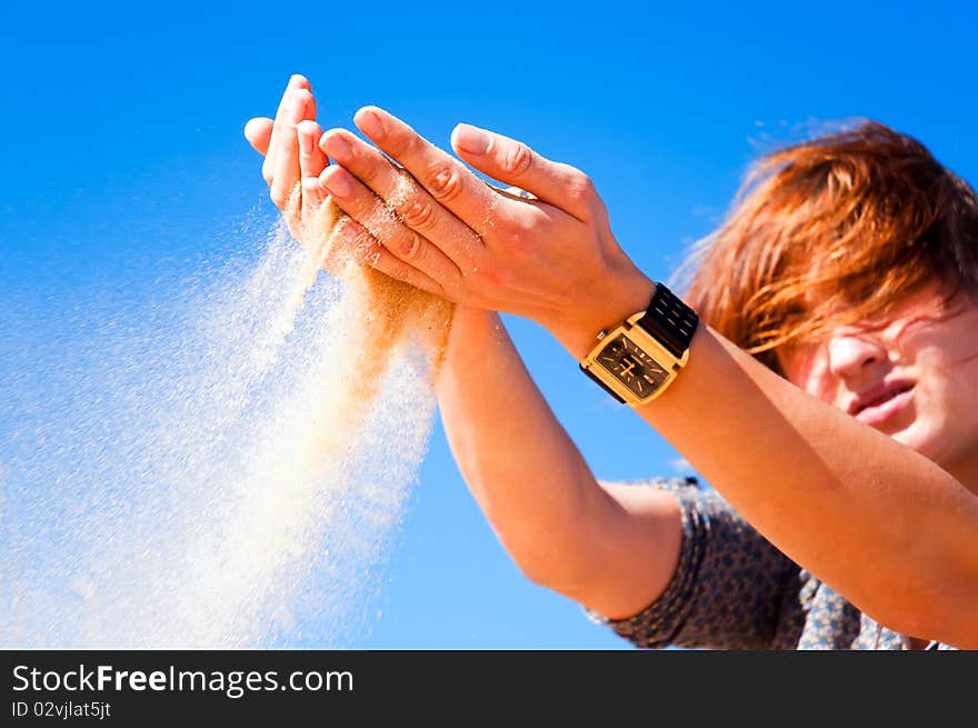 Sand flows through a woman's hand. Sand flows through a woman's hand