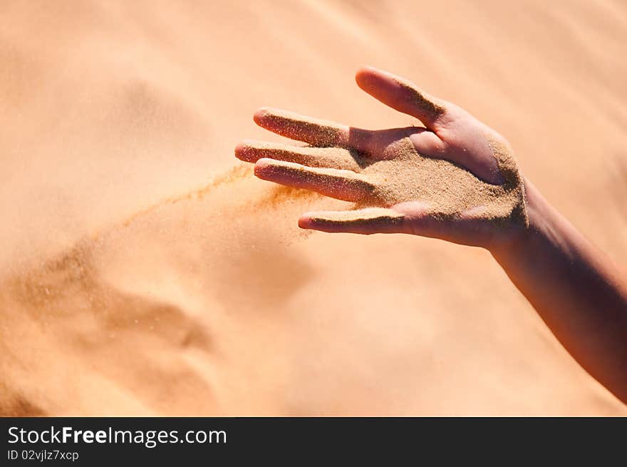 Sand is falling from girl's arm. Sand is falling from girl's arm