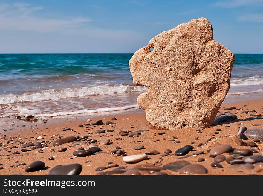 Stone in the shape of the head of a lion on a background of sea. Stone in the shape of the head of a lion on a background of sea