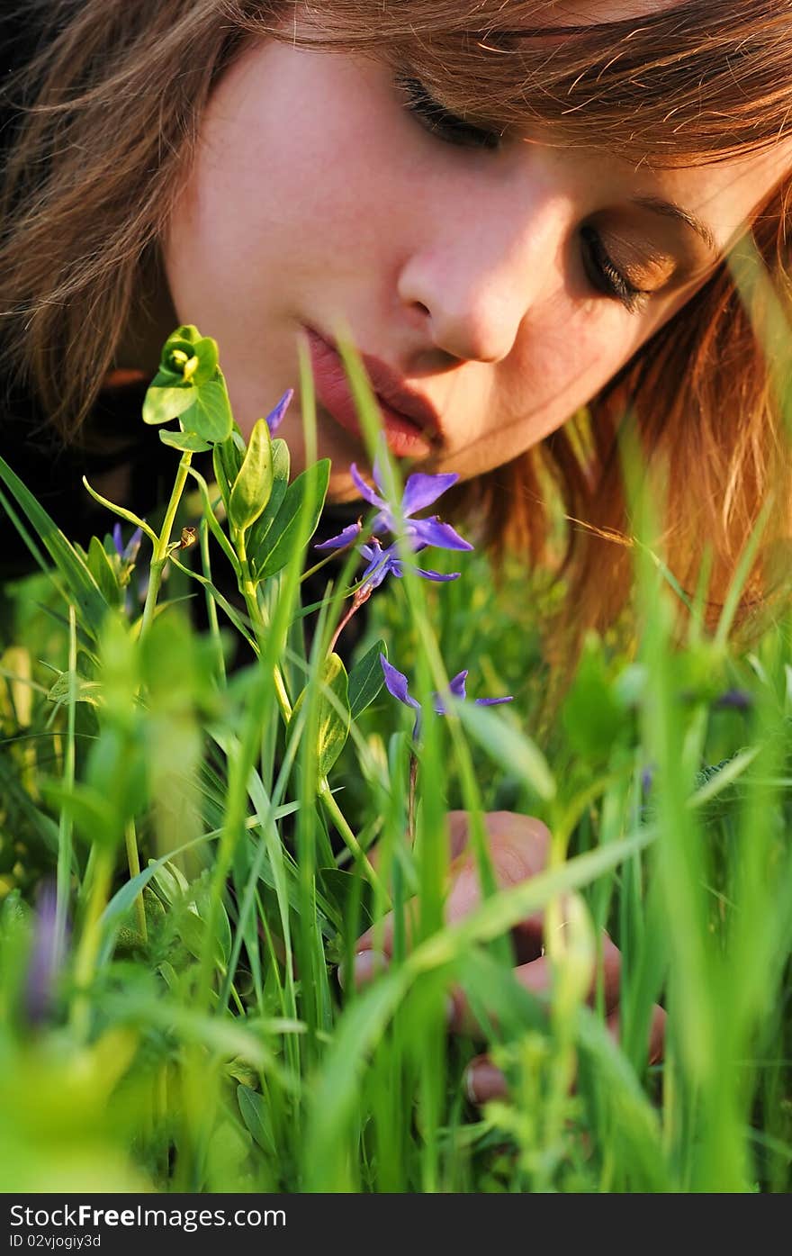 The girl bent over the ground to see the flower. The girl bent over the ground to see the flower