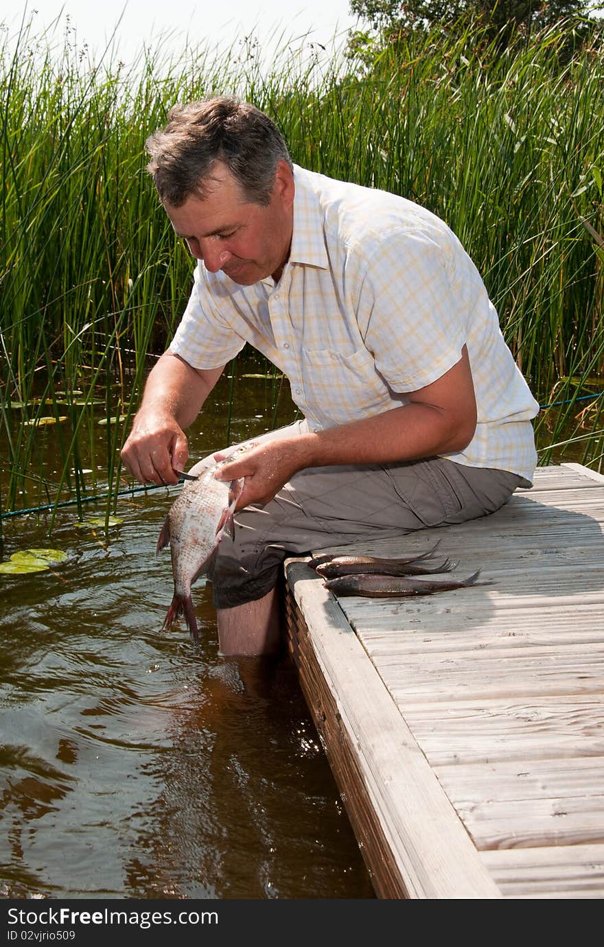 Senior Man Scaling Fish