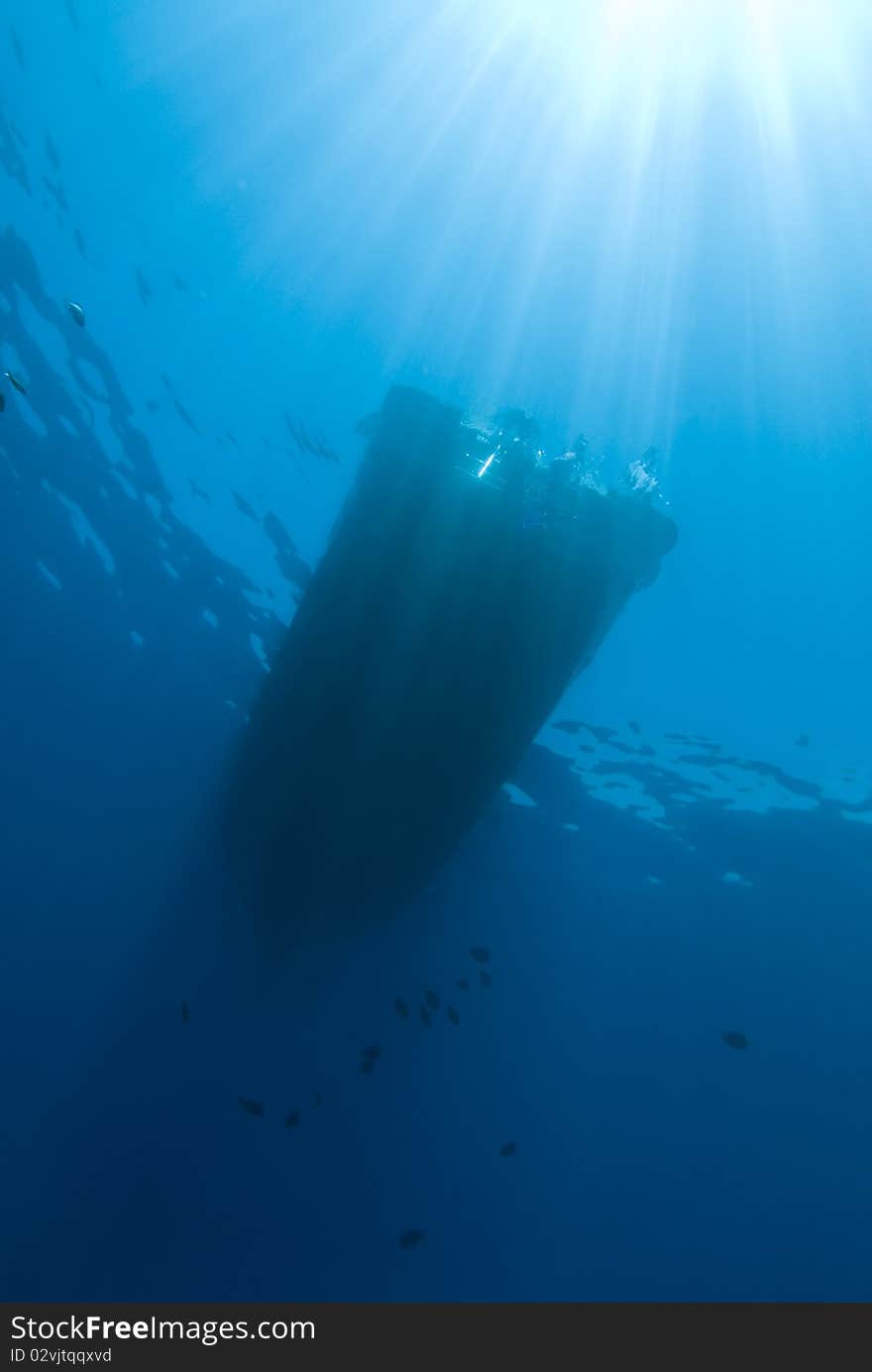 Underwater View Of Boat Silhouette With Sunrays.