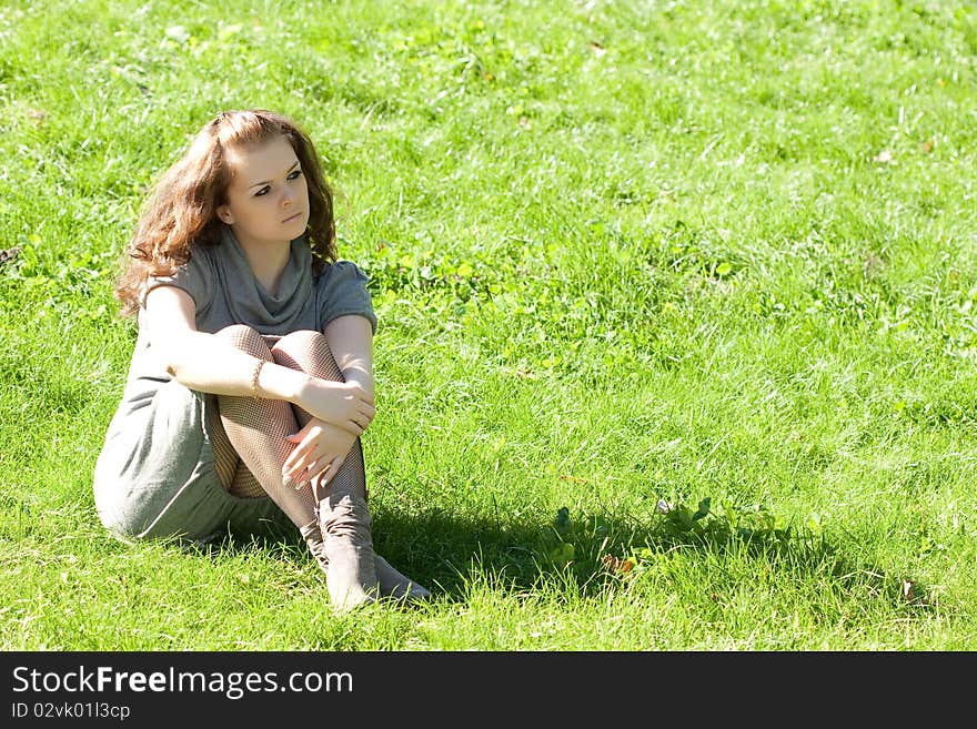 Girl sitting on green grass