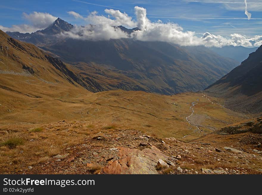 Alpin wetland at 2615 meters on the sea-level. Top of the Valle delle Messi, Brixia province, Lombardy region, Italy. Pietra Rossa Pass (2890 meters on the sea-level) as background