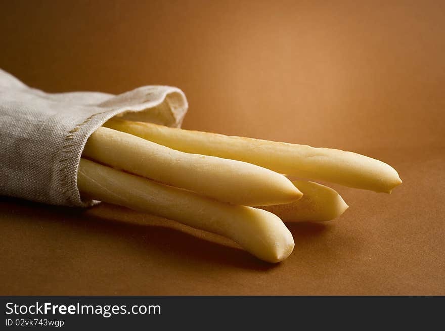 Bread sticks in sack on brown background