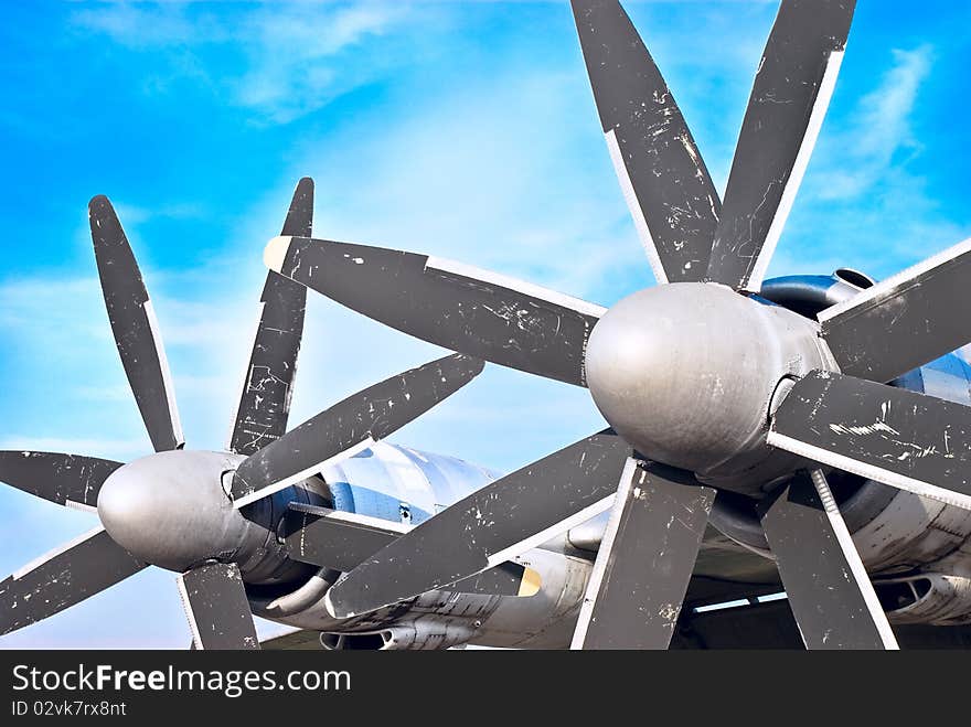 Plane motor with propeller and air intake against blue sky