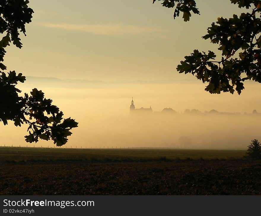 Church in the fog with a tree in the foreground