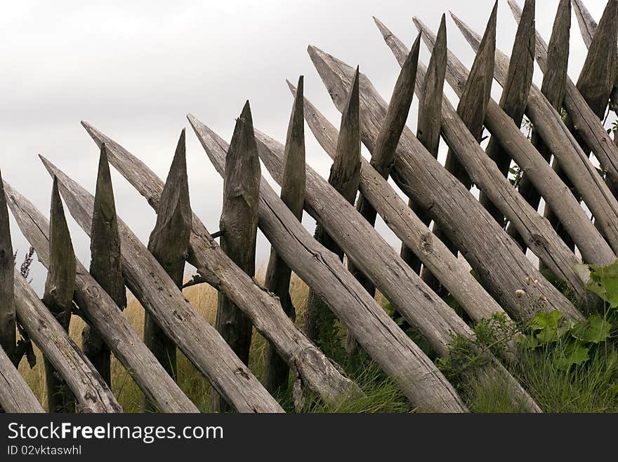 The reconstructed fortifications at Dybboel Banke in Denmark. Close-up wooden palisades all over. The reconstructed fortifications at Dybboel Banke in Denmark. Close-up wooden palisades all over.