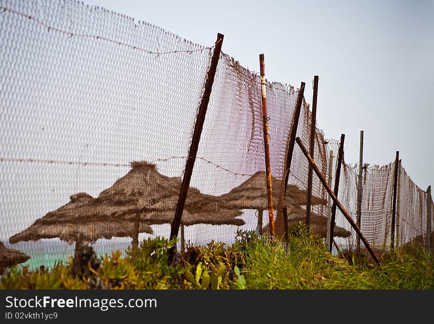 Fence from a rusty metal grid against a sea beach