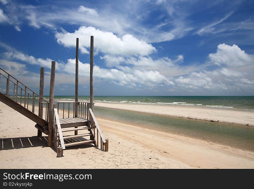 Wood bridge to the sea with blue sky