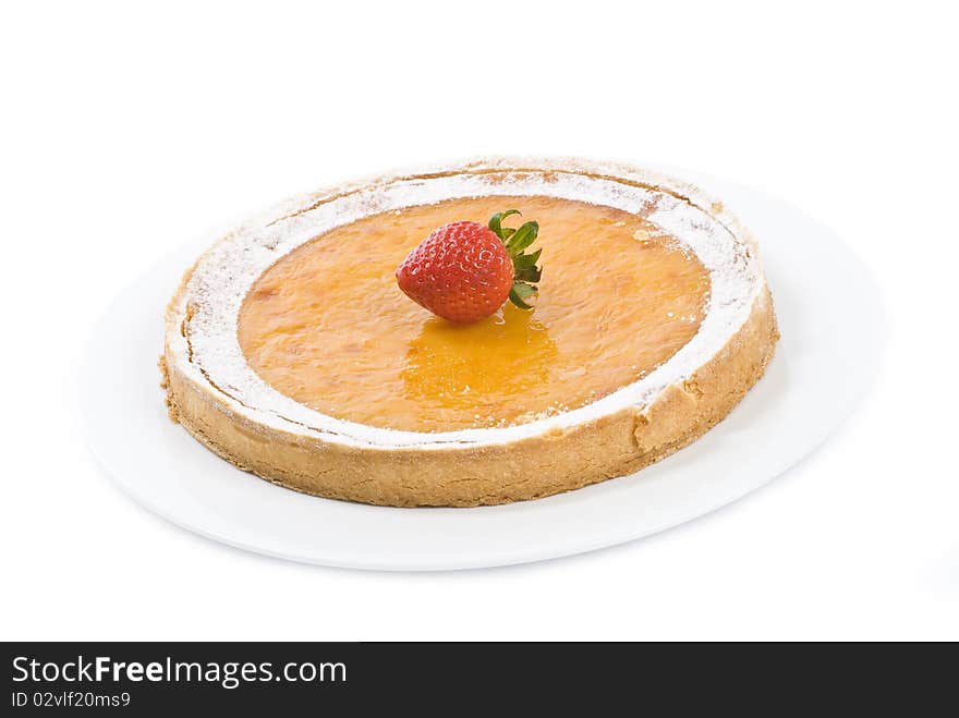 A fancy lemon tart on a white plate, decorated by one strawberry, on white. A fancy lemon tart on a white plate, decorated by one strawberry, on white.