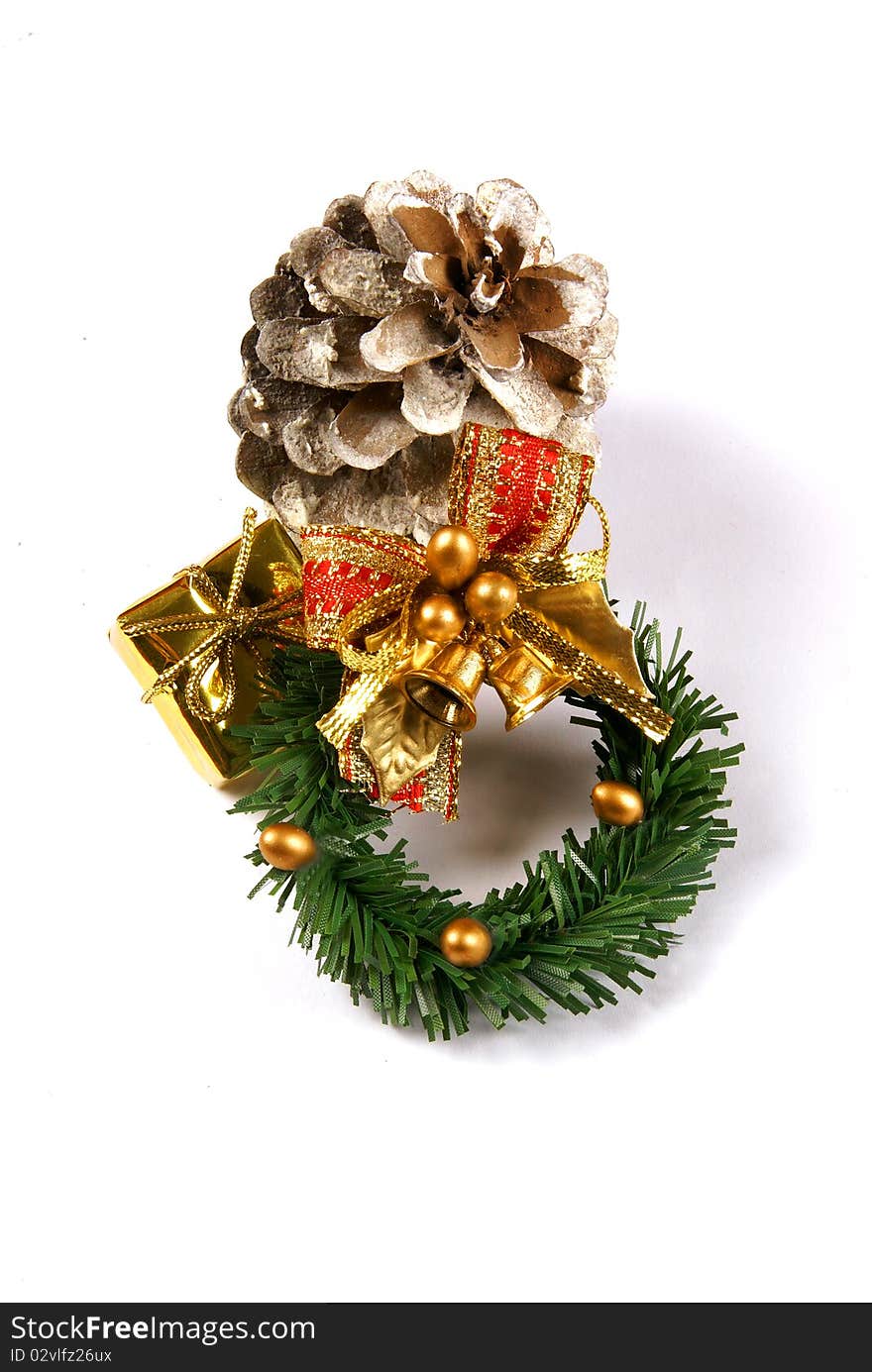 Christmas wreath with a gold present and frosted pine cone isolated on a white background. Christmas wreath with a gold present and frosted pine cone isolated on a white background