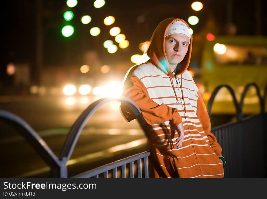 Displeased young punk slanging at the street at night. Displeased young punk slanging at the street at night