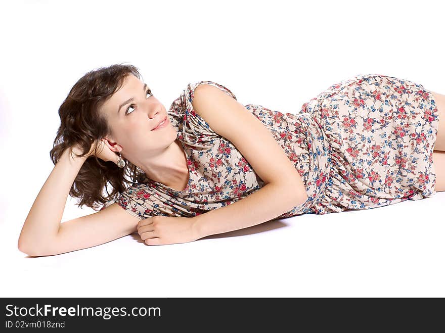 Young woman lying on the floor. White background. Studio shot. Young woman lying on the floor. White background. Studio shot.