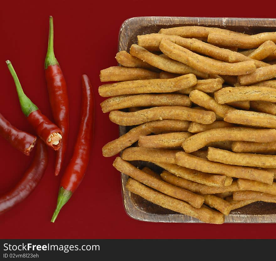 Chilli and sticks on red background. Chilli and sticks on red background