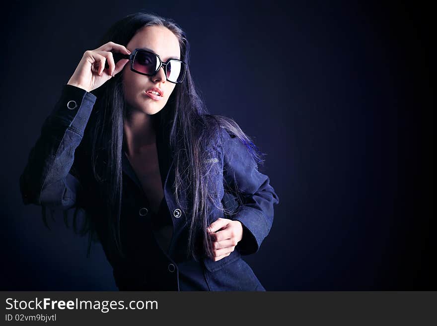 Fashion photo, a model is posing over black background. Fashion photo, a model is posing over black background