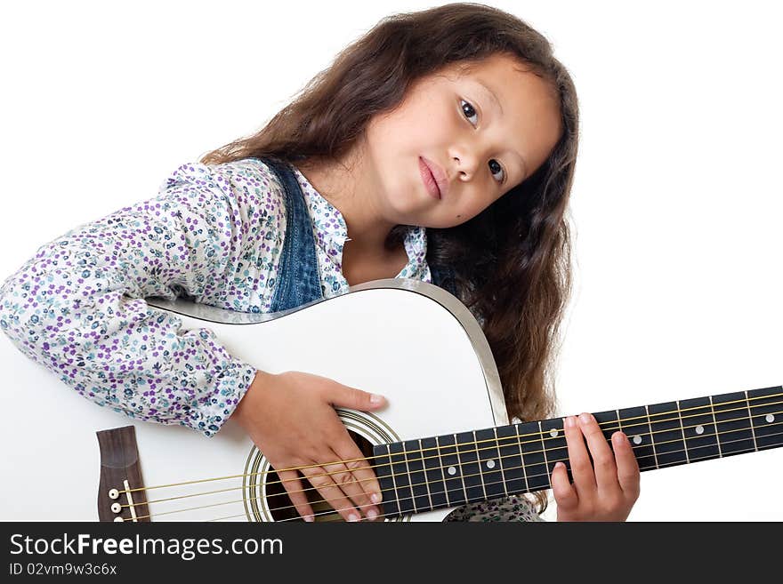 Girl plays the guitar, portrait of a child with music instrument before white background