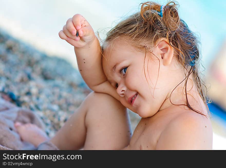 Portrait of smiling cute toddler girl on sea background