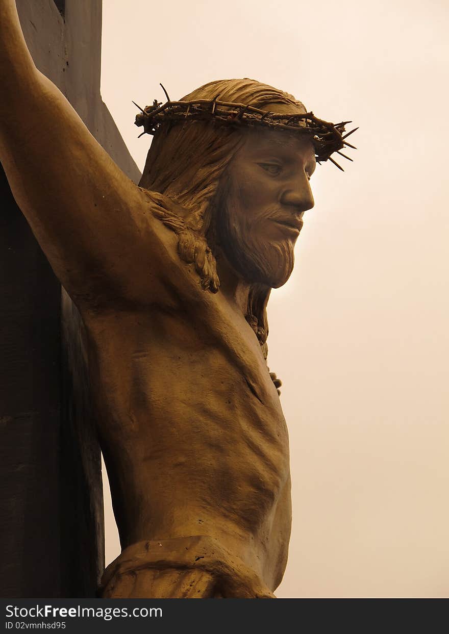 Bronze Christ on the Cross, photograph taken from a Church garden in Mexico