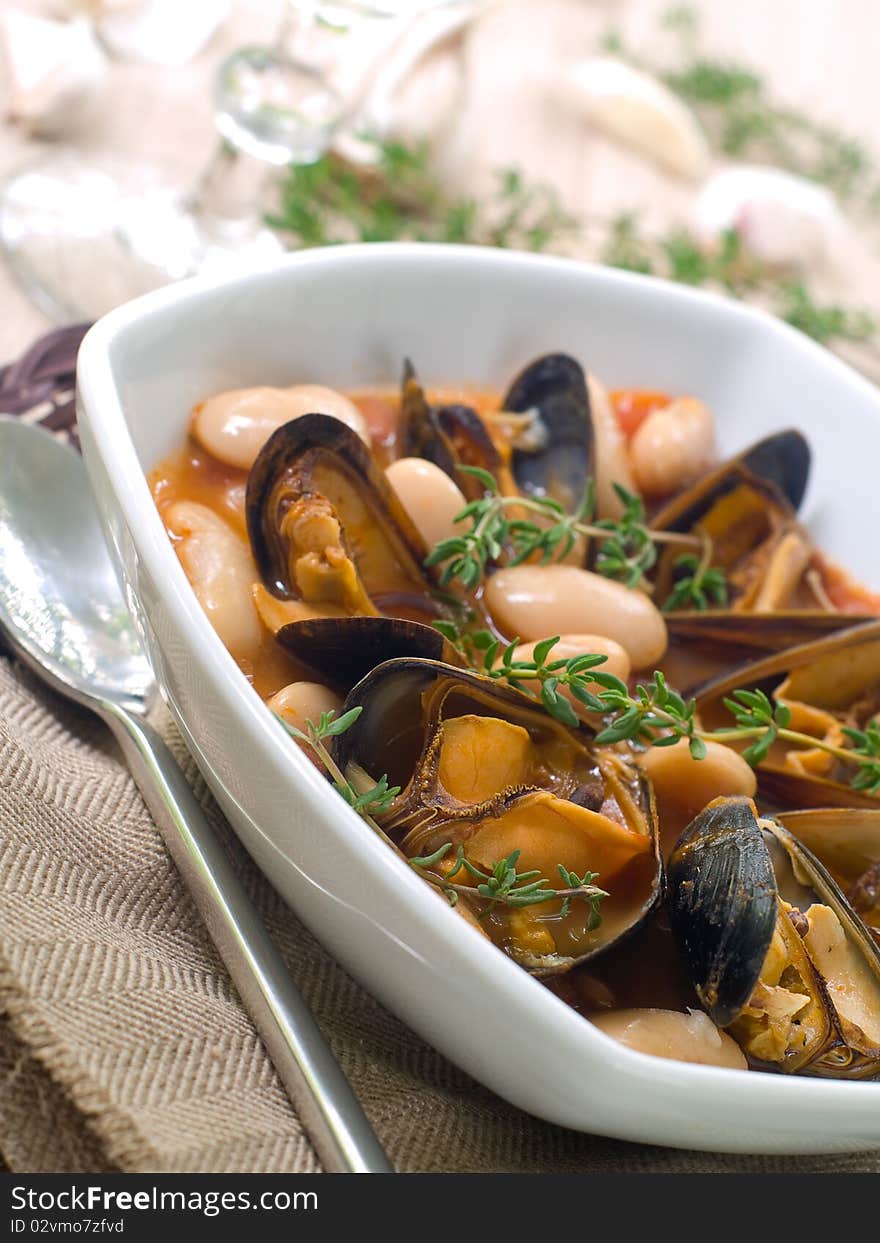 Mussel soup with bean and thyme on bowl