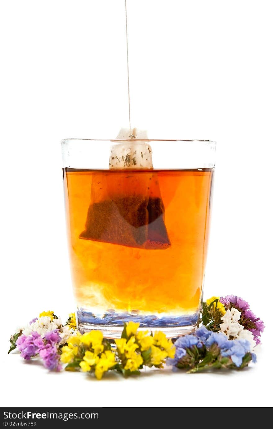 Hot tea in glass cup with flowers. Isolated on white background. Hot tea in glass cup with flowers. Isolated on white background