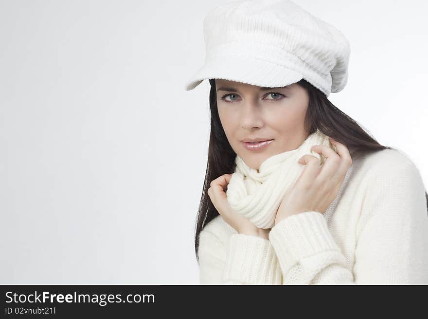 Young woman in soft white sweater and cap. Young woman in soft white sweater and cap